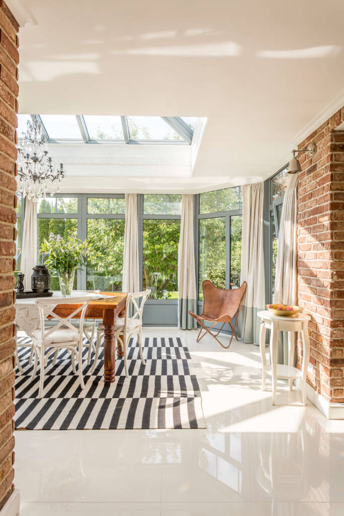 solarium sun room as example of home additions featuring exposed brick, tall windows and skylight