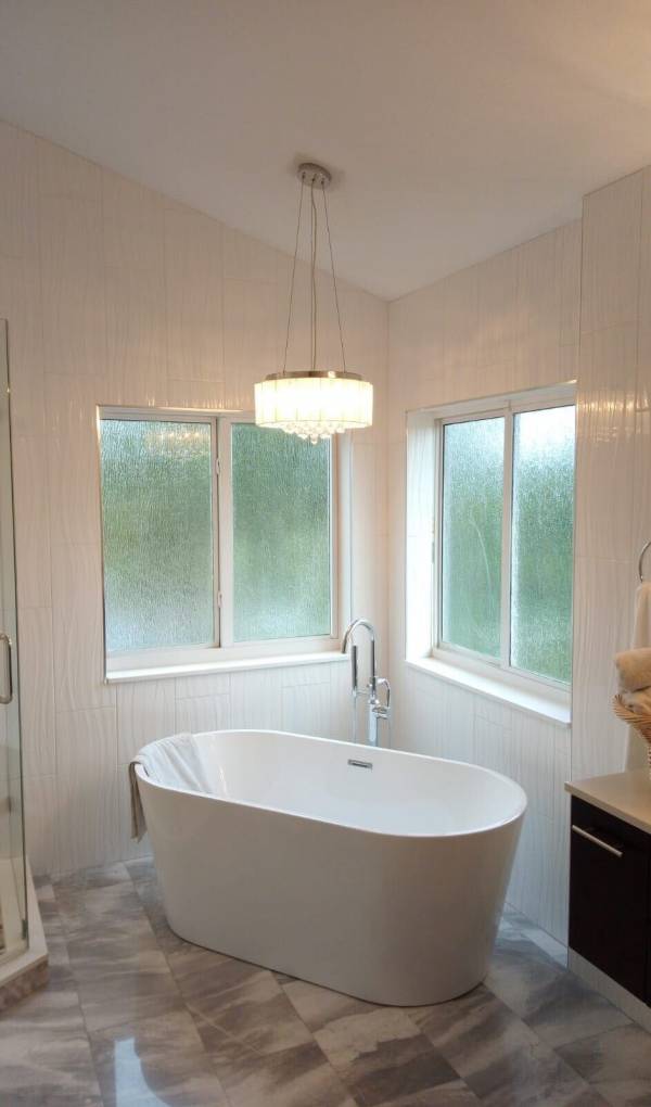 Large bathtub with light fixture overhead