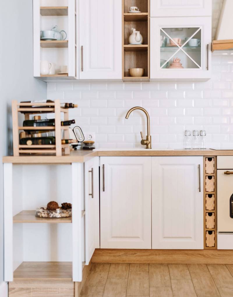 example of home additions featuring bright updated kitchen in classic white and blonde wood